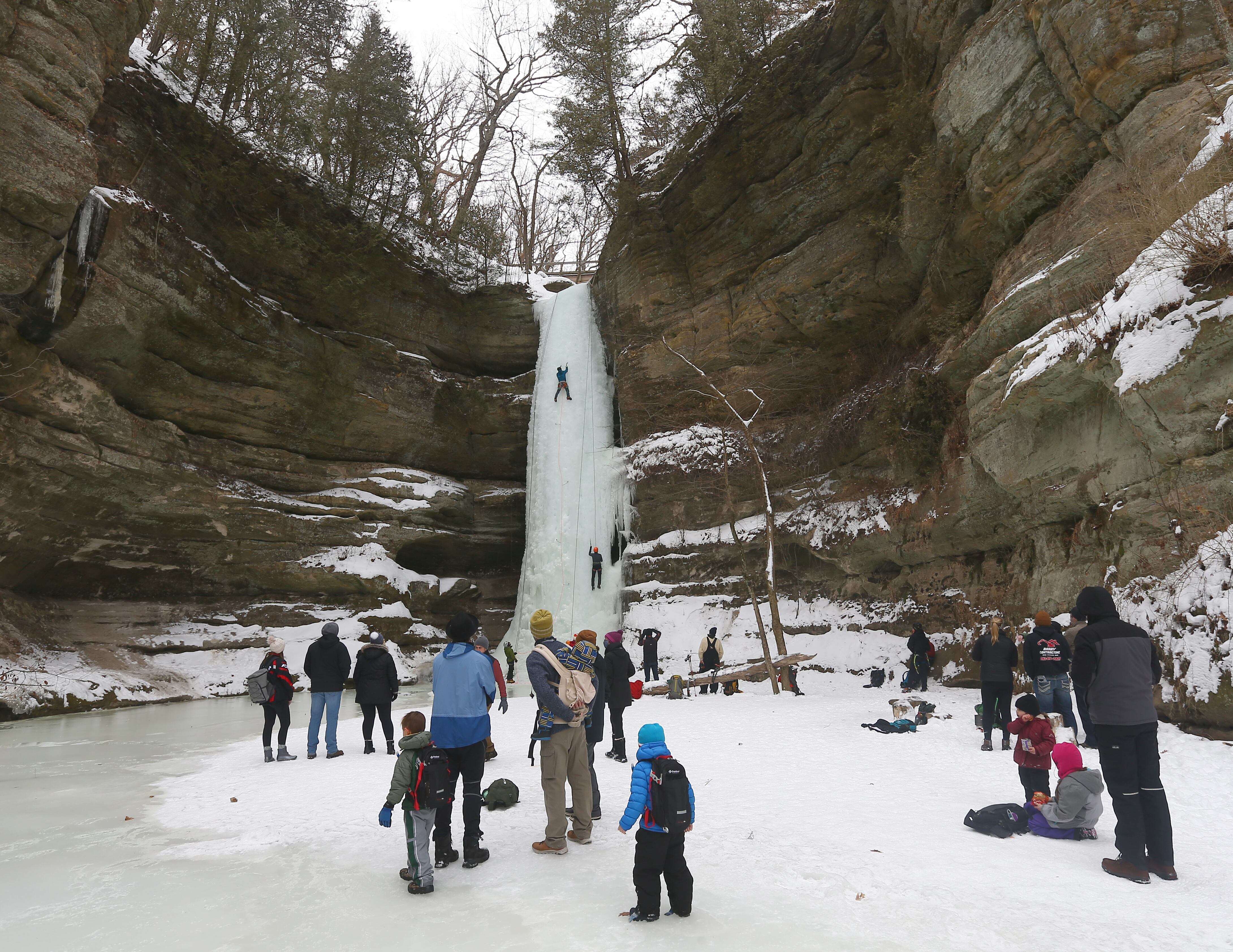 Climbers climb an ice fall at Wildcat Canyon as speectators watch in Starved Rock State Park on Sunday Feb. 21, 2021.