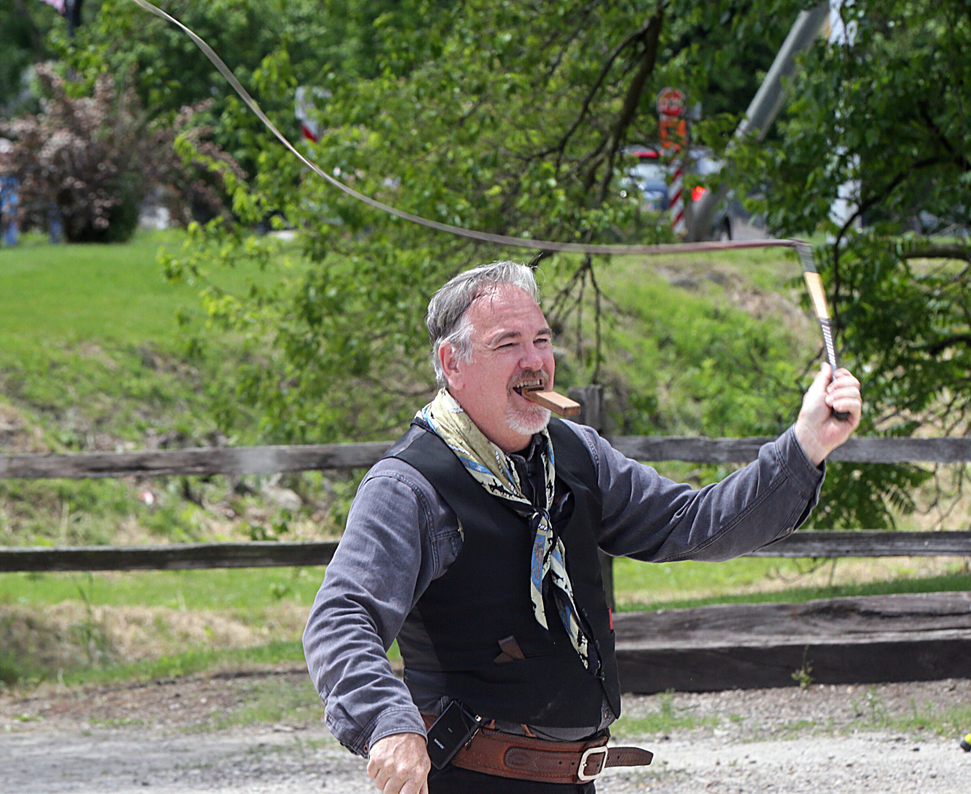 Chris Camp, "The Whip Guy" uses whips while playing a harmonica at the Wild Bill Days event at the La Salle County Historical Society in Utica.